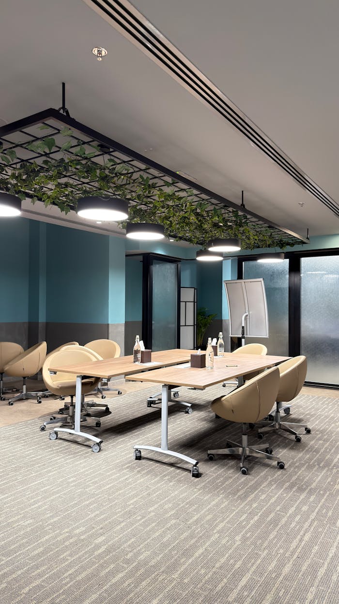 Contemporary conference room with beige chairs and plant decor. Perfect space for meetings.